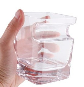 Hand holding clear cigar glass with holder